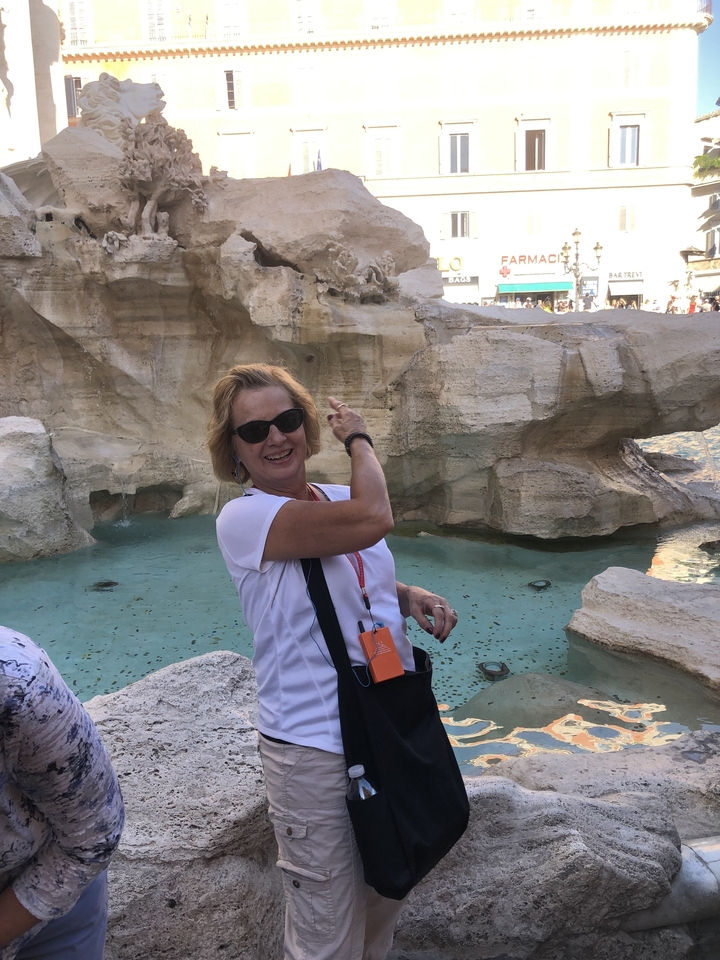 Femme posant avec une fontaine en arrière-plan.