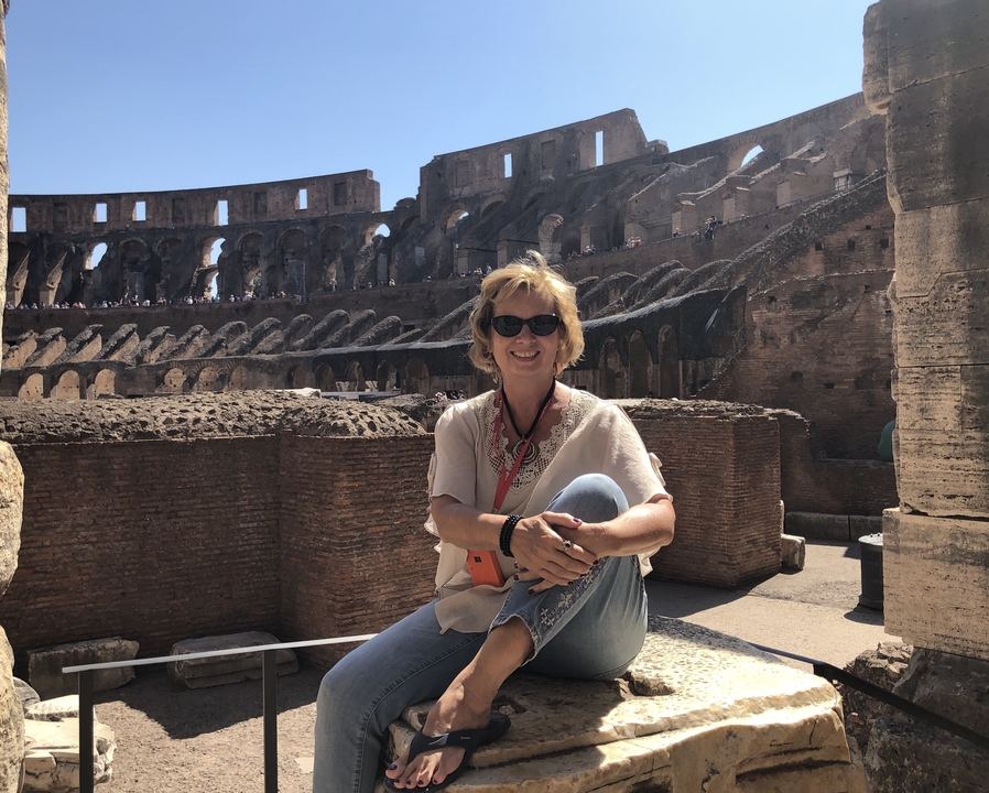 Femme assise avec le Colisée en arrière-plan.