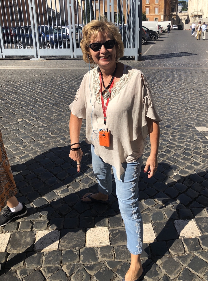 Femme debout sur une rue pavée.