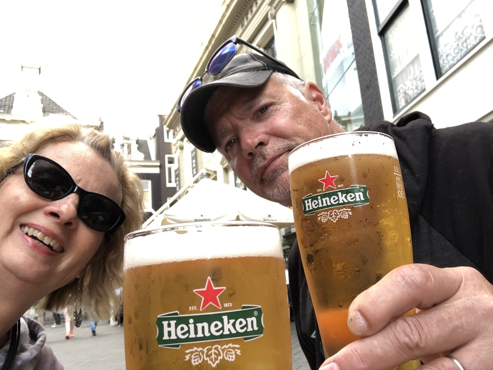 Couple tenant des bières Heineken à l'extérieur.