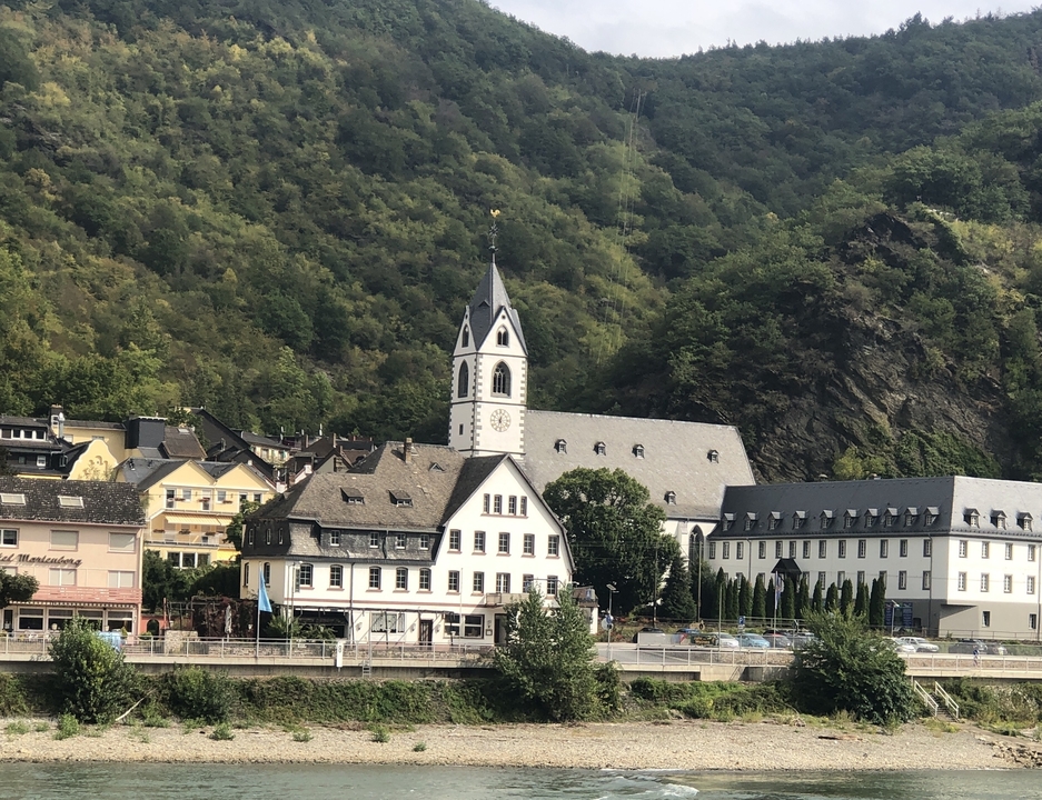 Vue pittoresque d'un village avec un clocher d'église dans un paysage vallonné.