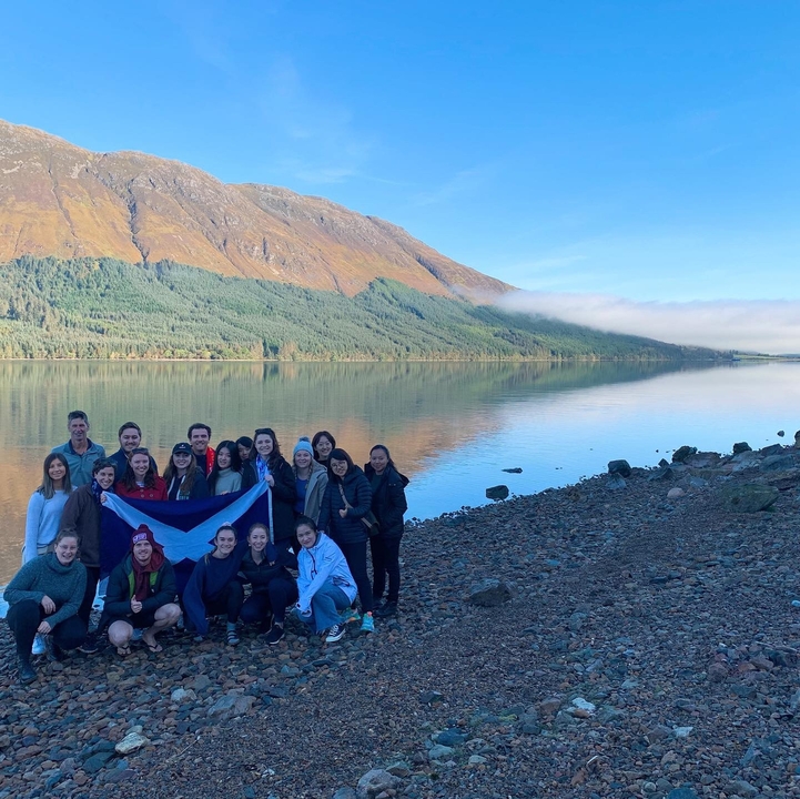Group with a Scottish flag by a loch.