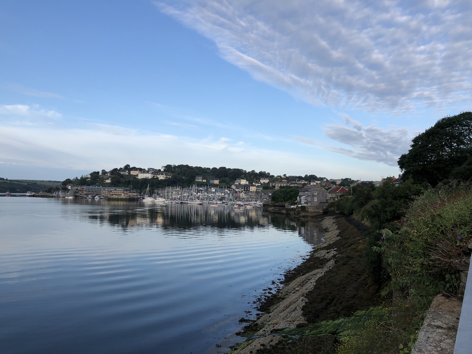 Vue panoramique d'un port avec des voiliers et une ville pittoresque.