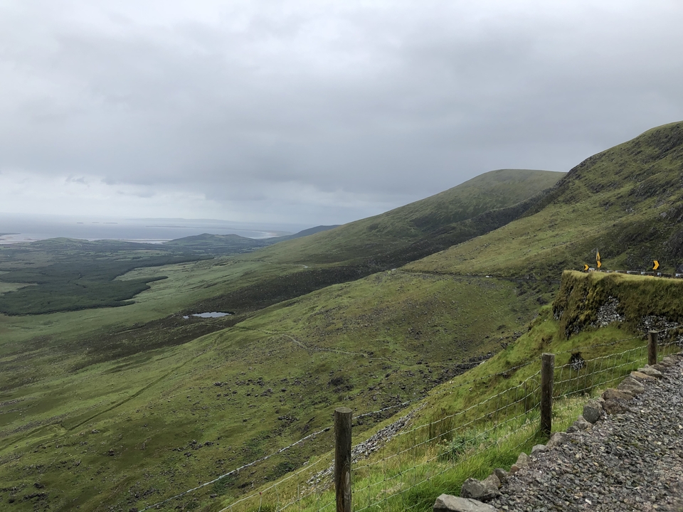 Collines vertes et paysage de montagne avec une route sinueuse.