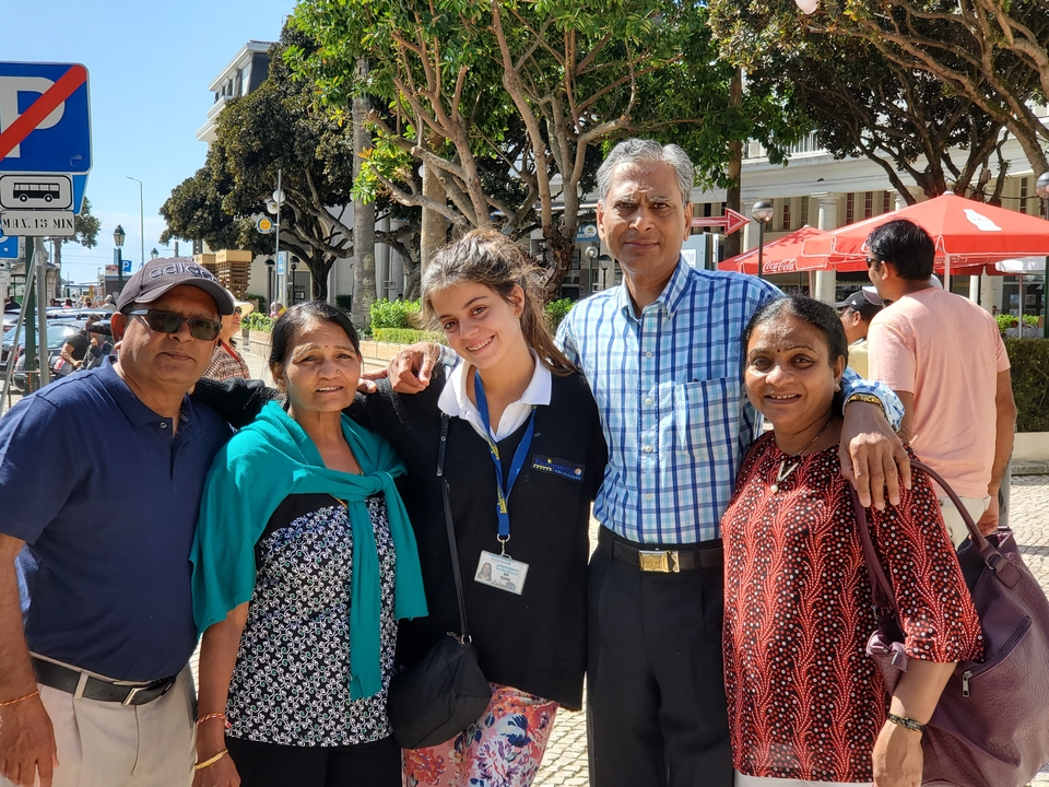 Groupe de personnes posant dans un cadre urbain extérieur avec des parapluies rouges.