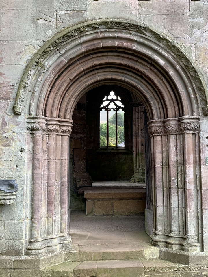 Arche de pierre historique encadrant une vue sur le paysage.