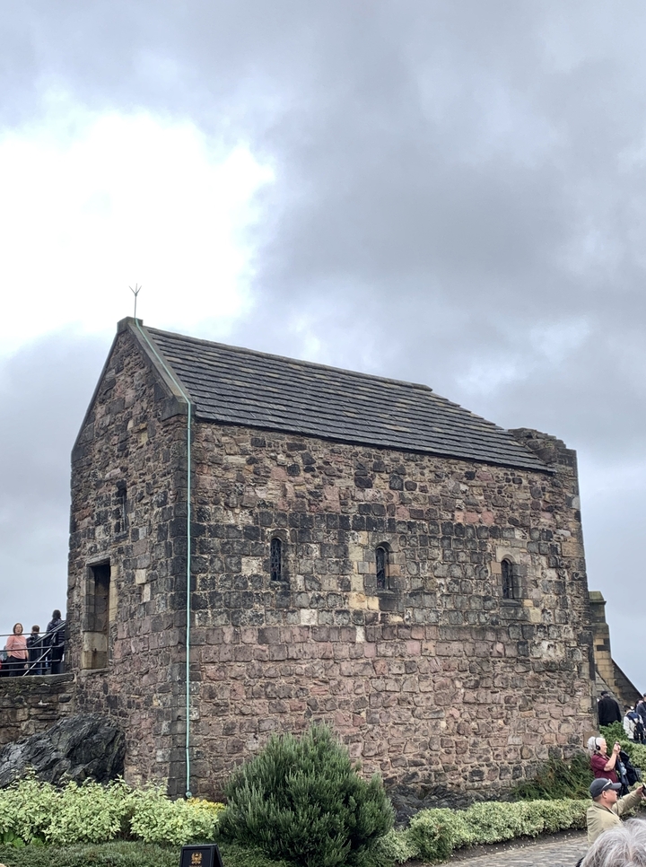 Une structure historique en pierre contre un ciel nuageux.