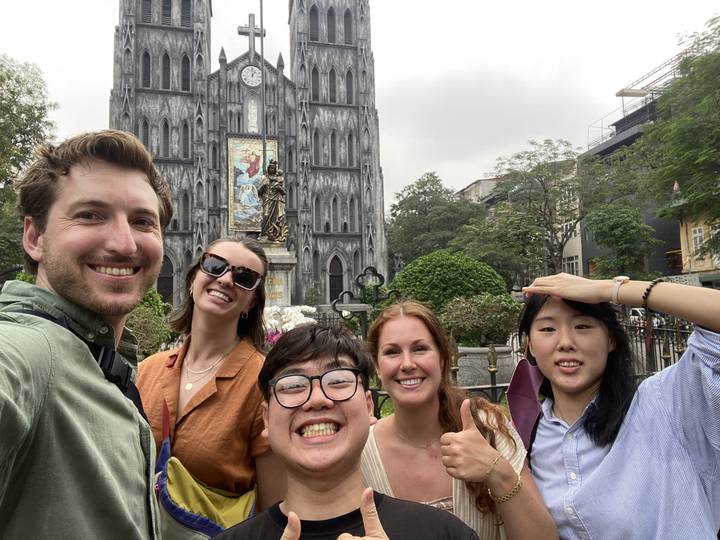 Groupe d'amis prenant un selfie avec une église en arrière-plan.