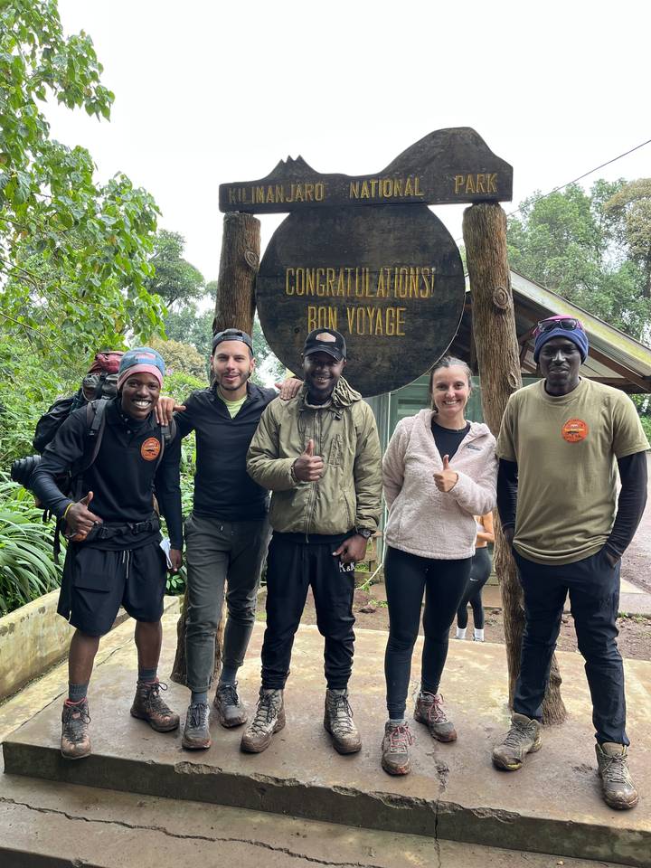 Groupe de personnes à un panneau d'entrée de parc.