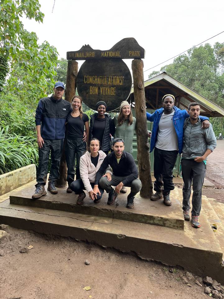 Groupe de personnes posant devant un panneau d'entrée de parc.