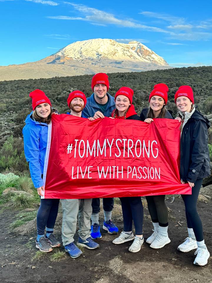 Groupe de randonneurs tenant une bannière avec vue sur la montagne
