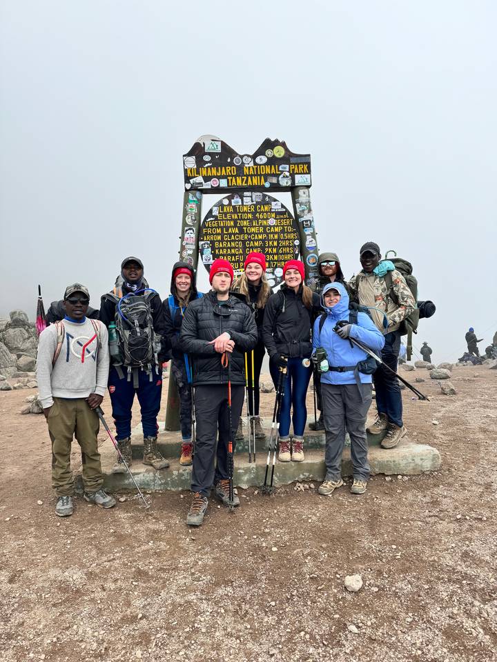 Groupe de personnes au panneau indicateur du mont Kilimandjaro