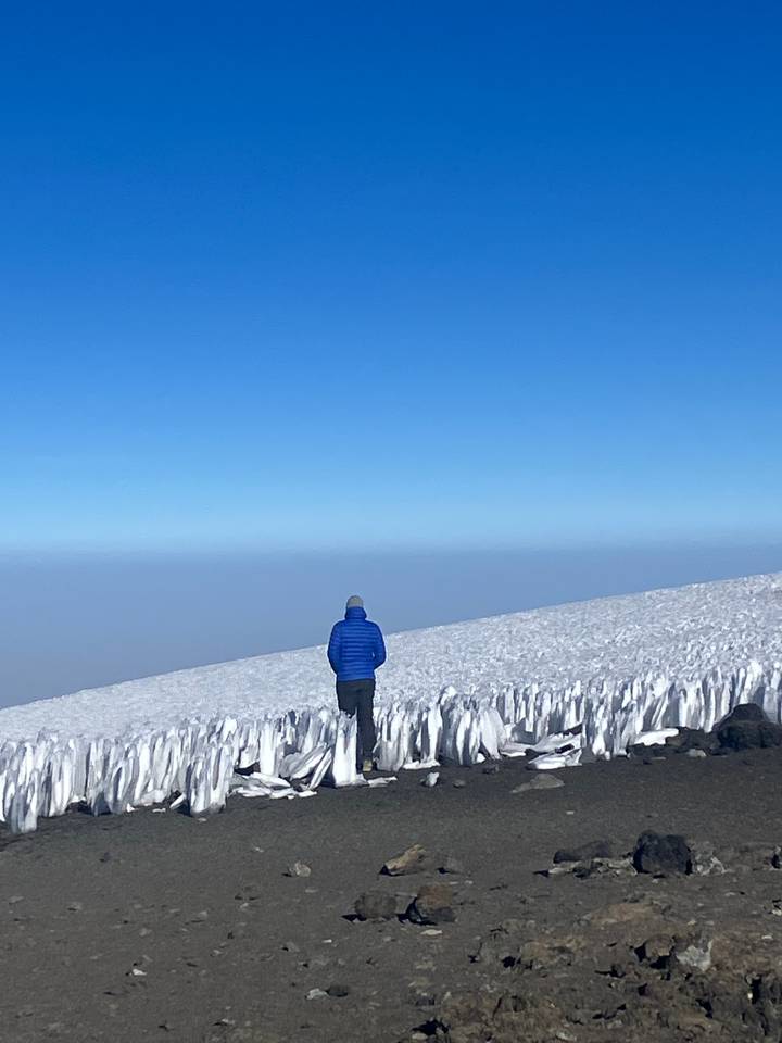 Personne debout devant une formation de glace glaciaire.