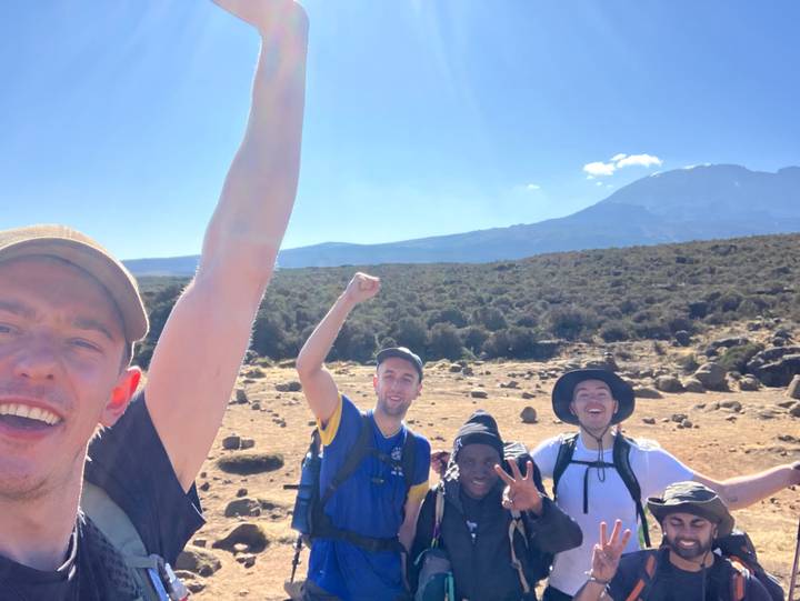 Groupe de personnes posant la tête en bas dans une région montagneuse.