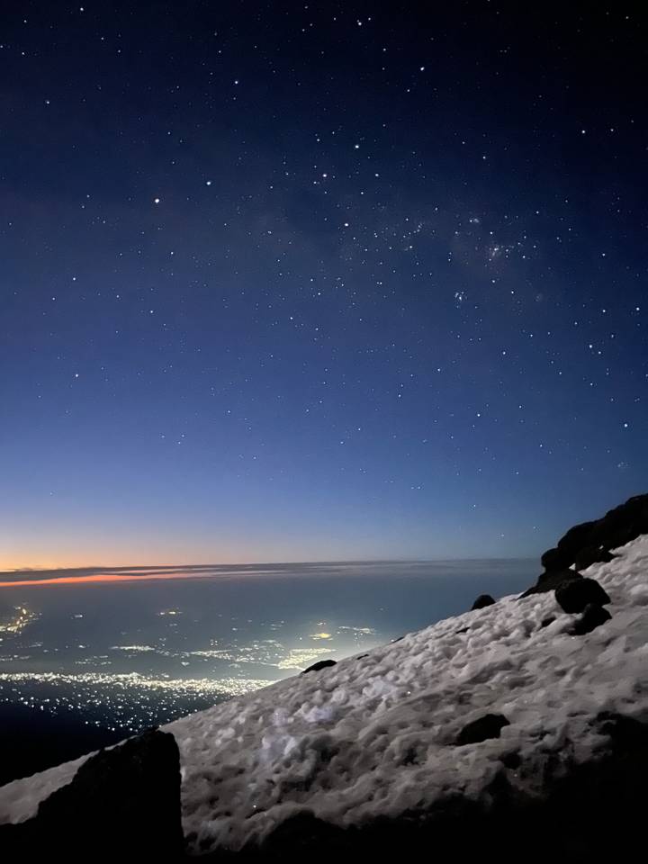 Ciel étoilé au-dessus d'un paysage enneigé au lever du soleil.