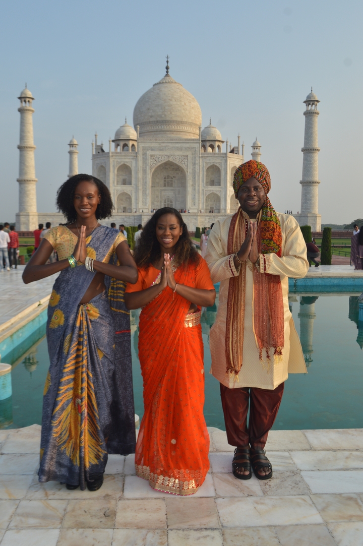 Des personnes vêtues de tenues traditionnelles posant devant le Taj Mahal.