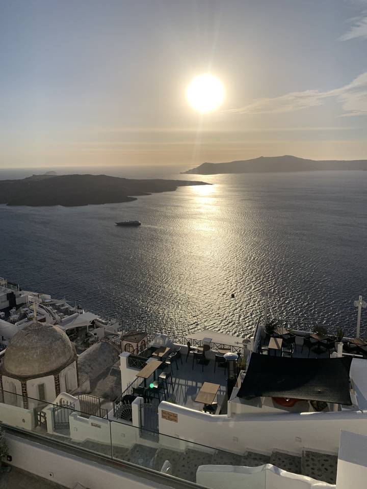 Vue du coucher de soleil sur la mer avec des bâtiments sur la côte.