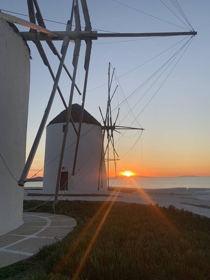Coucher de soleil derrière un moulin à vent traditionnel.