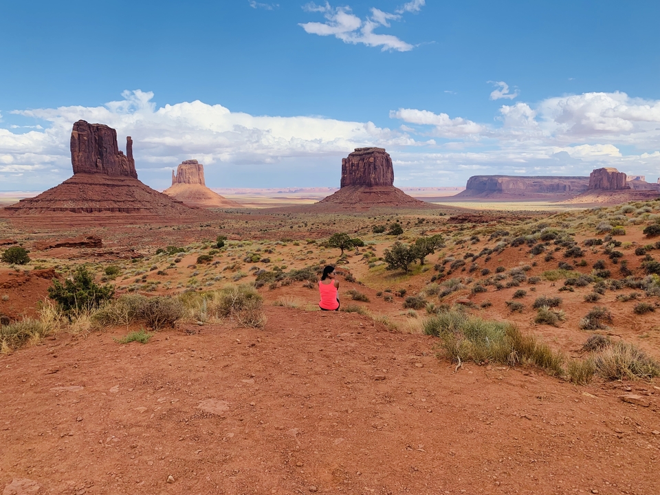 Personne assise devant des formations désertiques emblématiques.