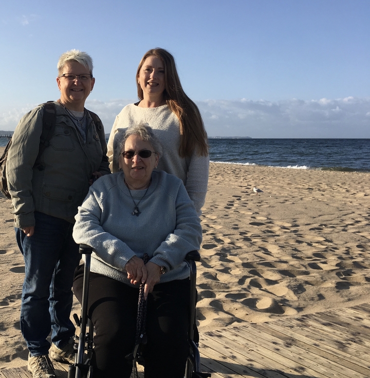 Trois personnes assises sur une plage de sable.