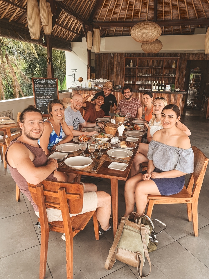 Groupe de personnes dînant ensemble à une table en bois.