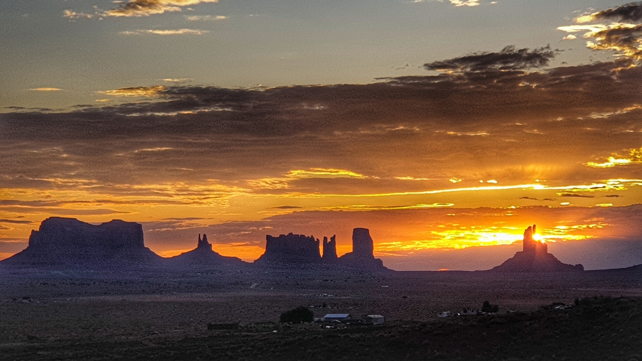 Vue du coucher de soleil sur Monument Valley avec des silhouettes saisissantes.