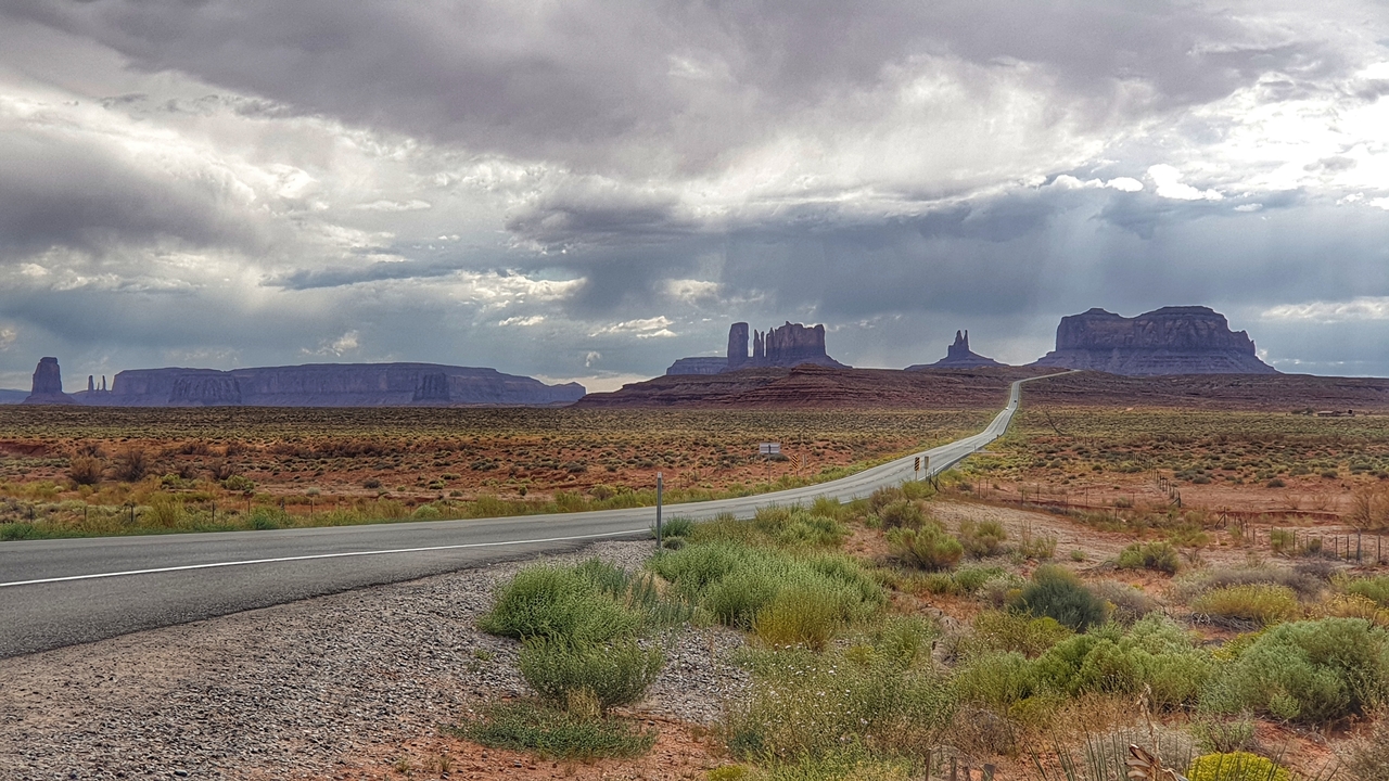 Route menant vers Monument Valley sous un ciel dramatique.