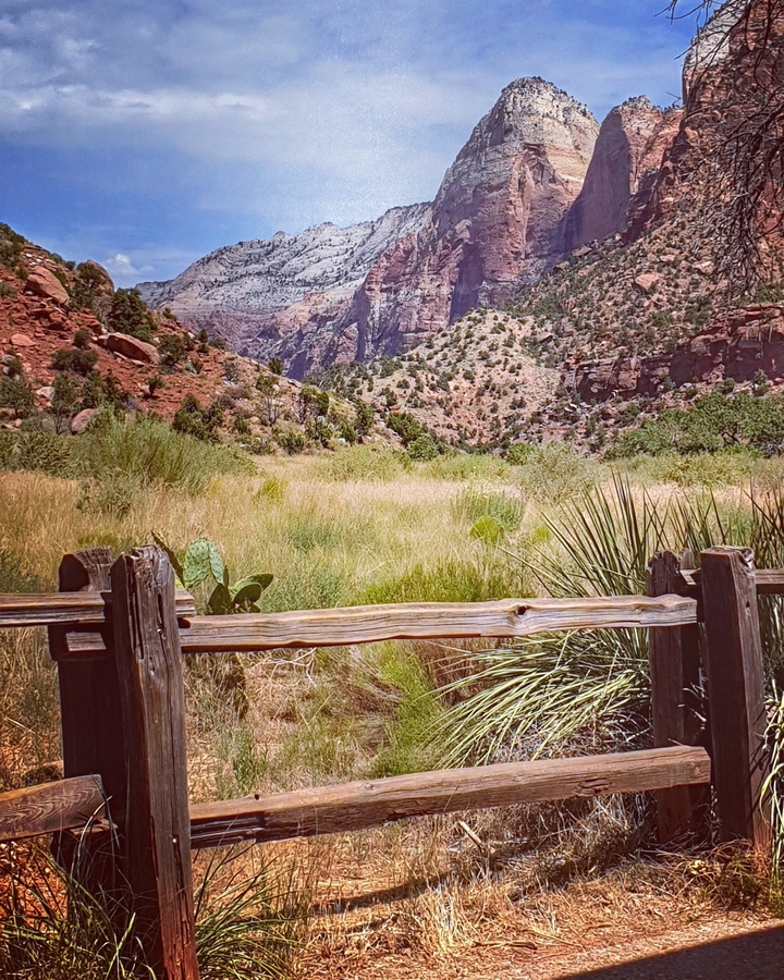 Clôture en bois rustique avec un paysage de canyon en arrière-plan.