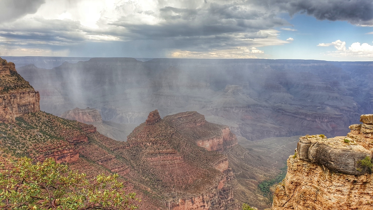 Nuages de pluie au-dessus du Grand Canyon avec de vastes formations rocheuses.
