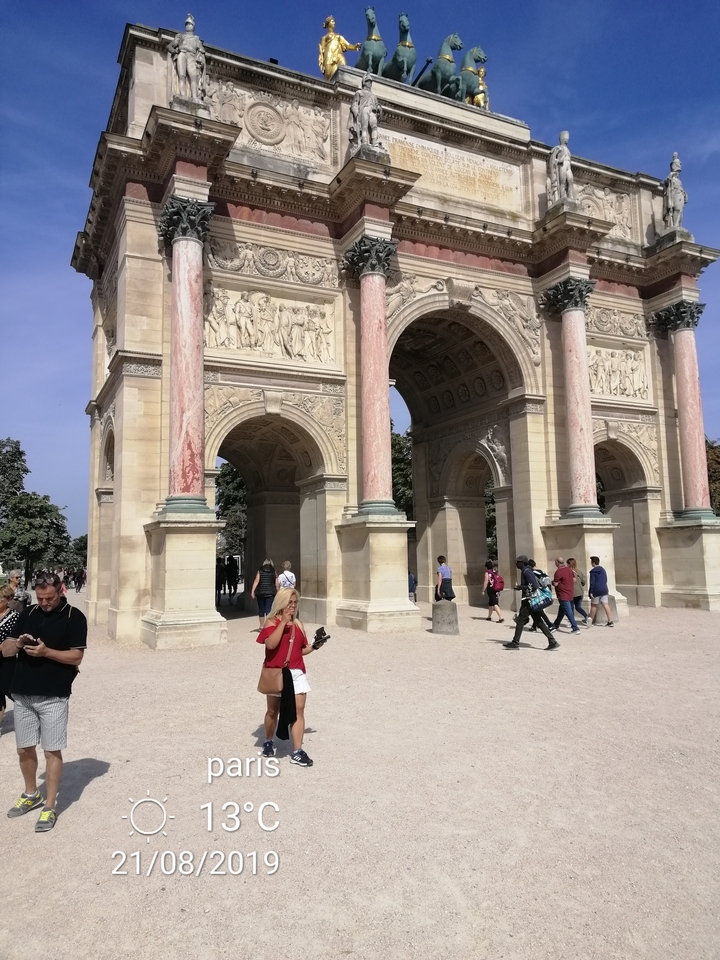Arc de Triomphe avec des gens autour et un ciel dégagé.