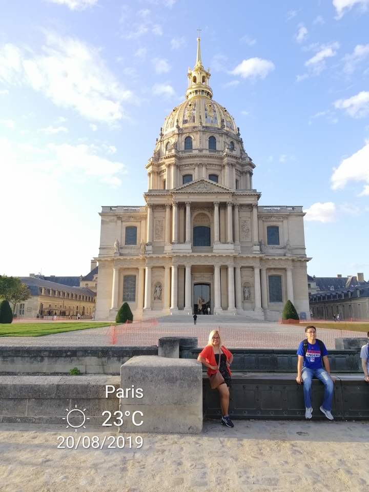 Des personnes debout devant un bâtiment historique.