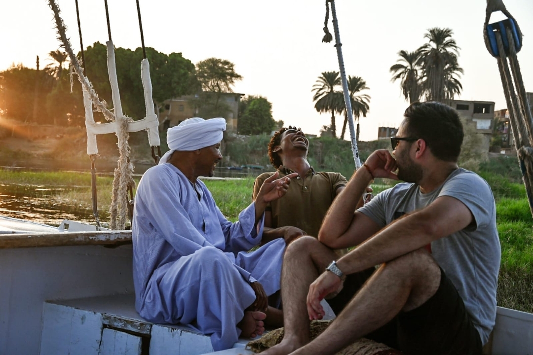 Des gens profitant d'une balade en bateau avec un coucher de soleil en arrière-plan.