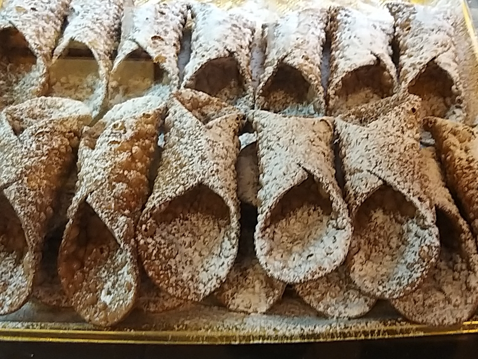 Gros plan de pâtisseries cannoli avec du sucre en poudre.
