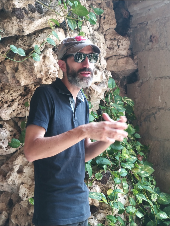 Personne gesticulant devant un arrière-plan rocheux.