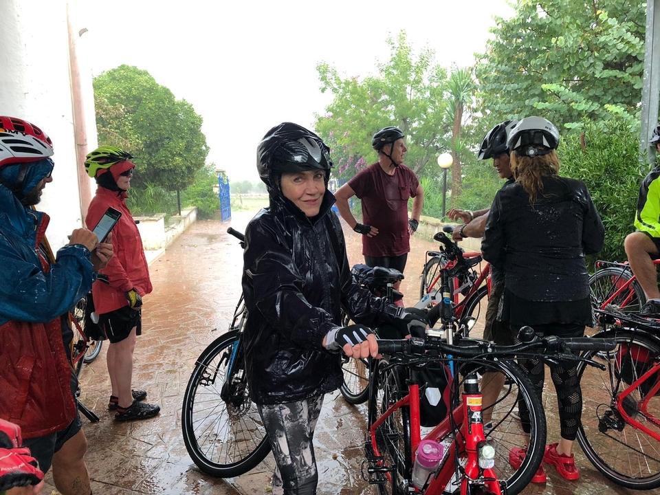 Des cyclistes en vêtements de pluie rassemblés pendant un orage.