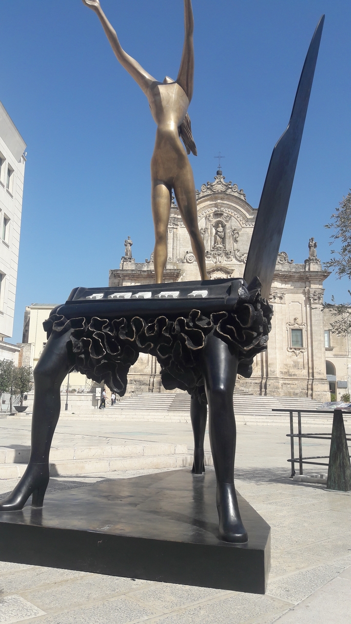 Sculpture artistique devant un bâtiment historique.