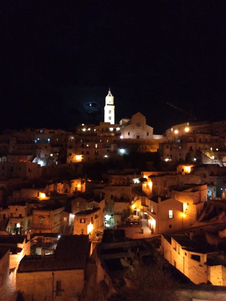 Vue nocturne d'une ville avec des bâtiments illuminés.