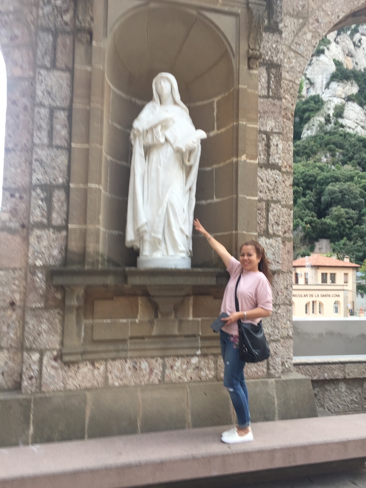 Femme posant à côté d'une statue.