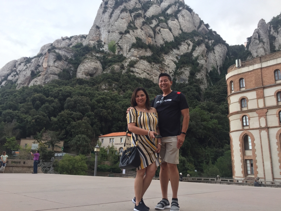 Couple posant devant un paysage montagneux.