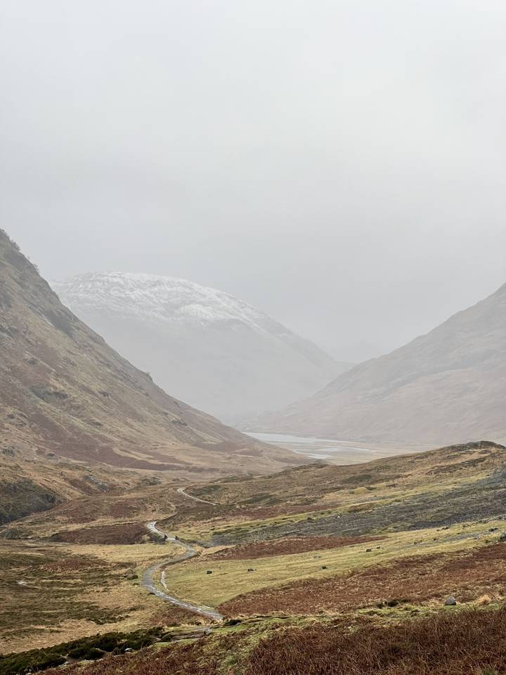 Paysage de collines ondulantes avec une atmosphère brumeuse.