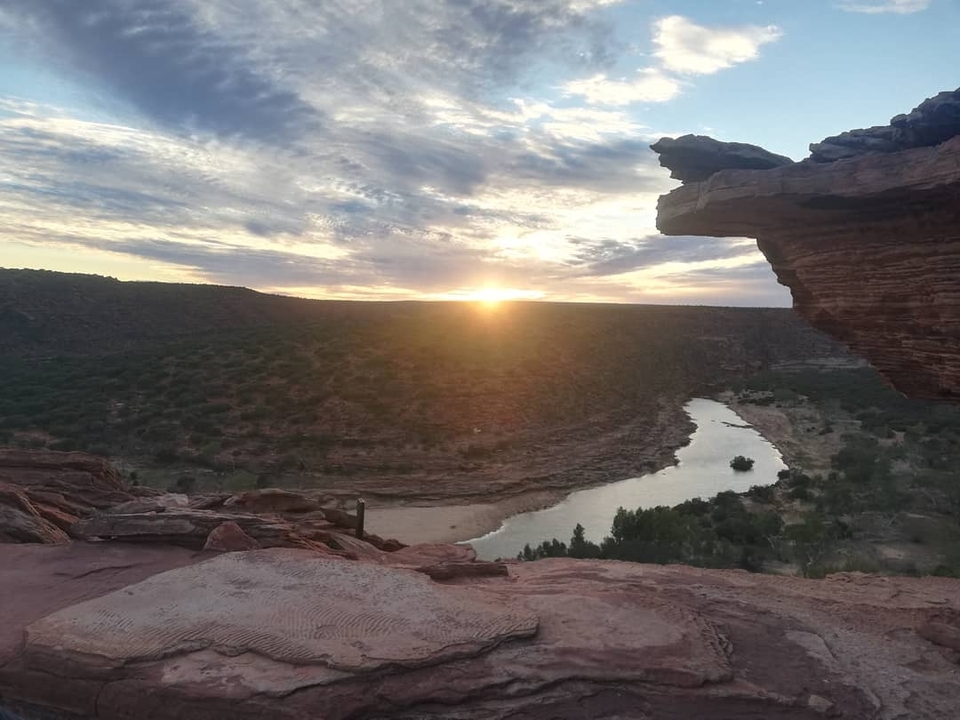 Coucher de soleil sur une rivière dans un paysage désertique.
