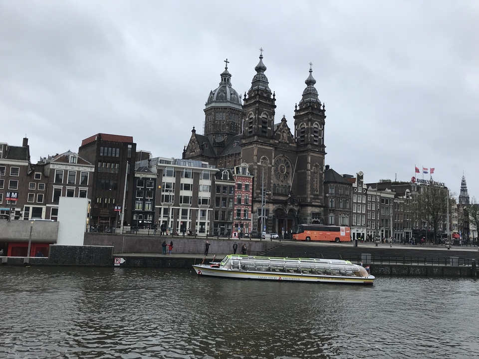 Vue d'une rivière avec un grand bâtiment historique et une péniche.