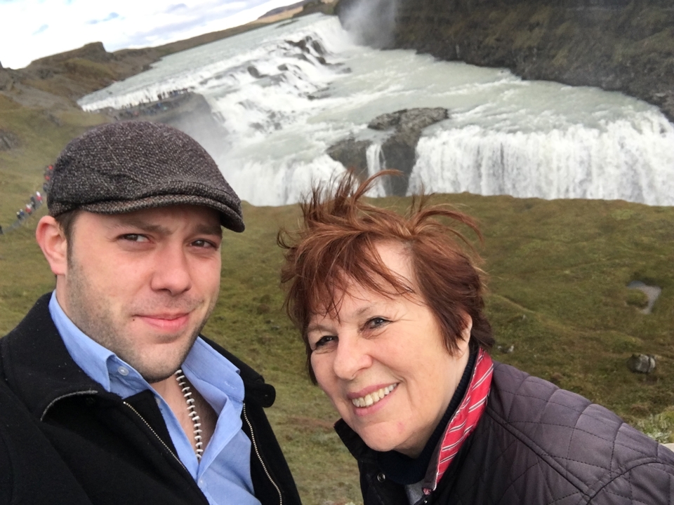 Deux personnes posant devant une grande cascade.