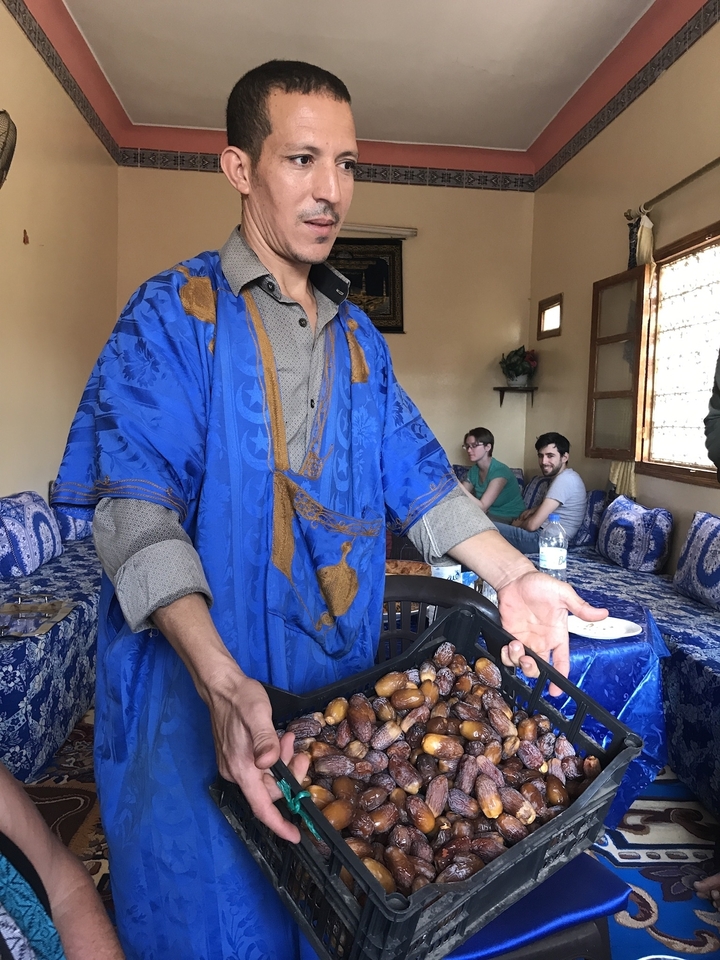 Personne en vêtements traditionnels servant de la nourriture à l'intérieur d'une pièce.