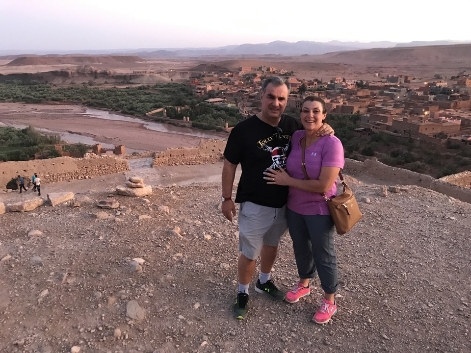 Couple posant sur une colline avec vue sur une petite ville.