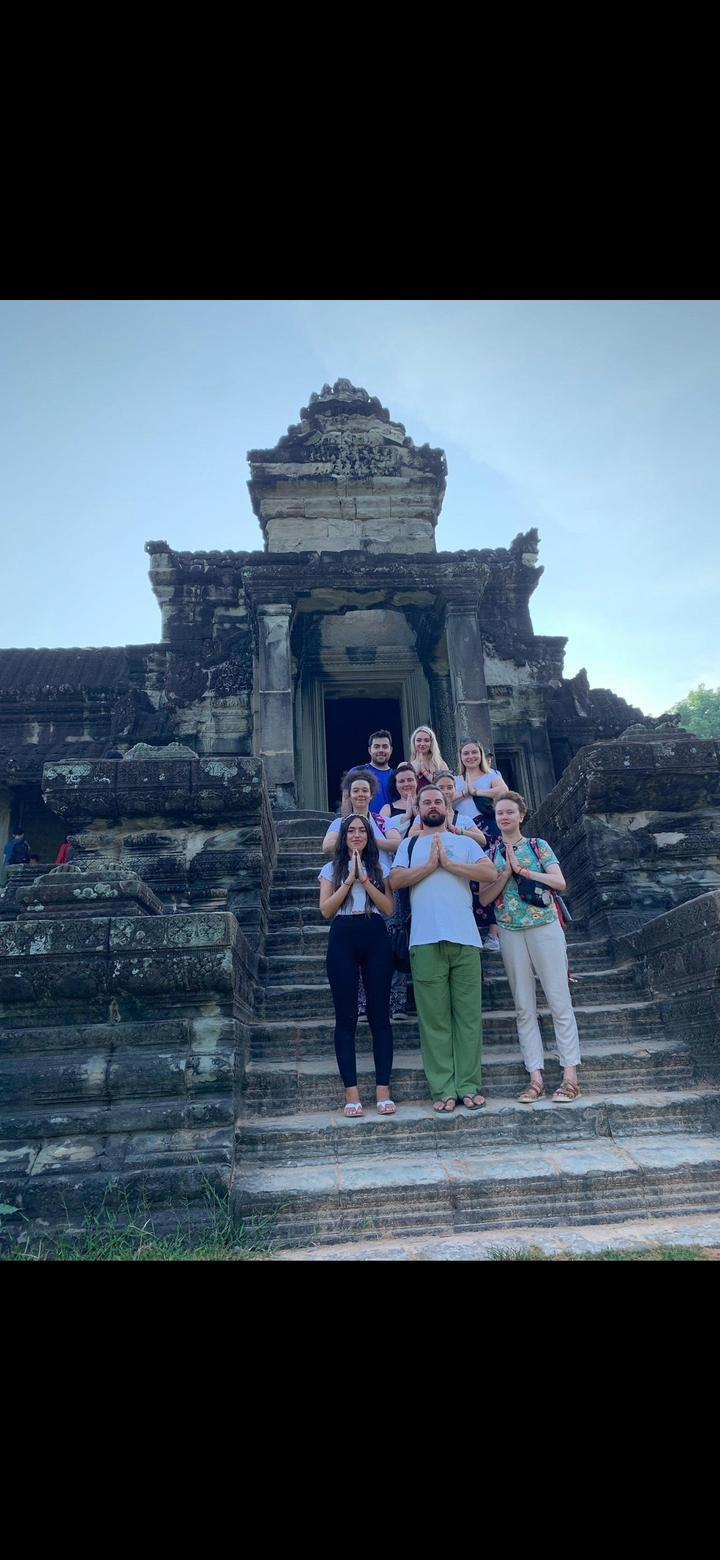 Groupe de personnes posant à l'entrée d'un temple historique.