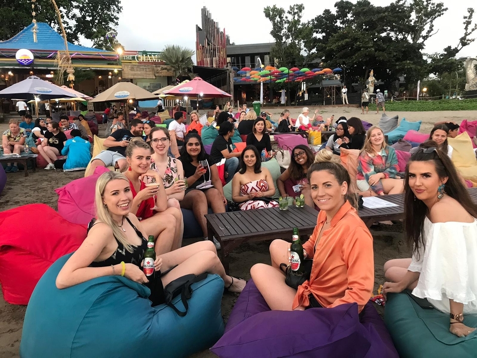 Groupe de personnes assises à l'extérieur dans un bar de plage.