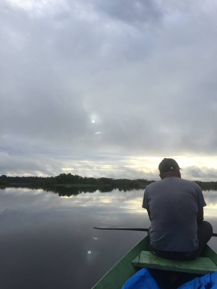 Personne assise sur un bateau regardant une rivière.