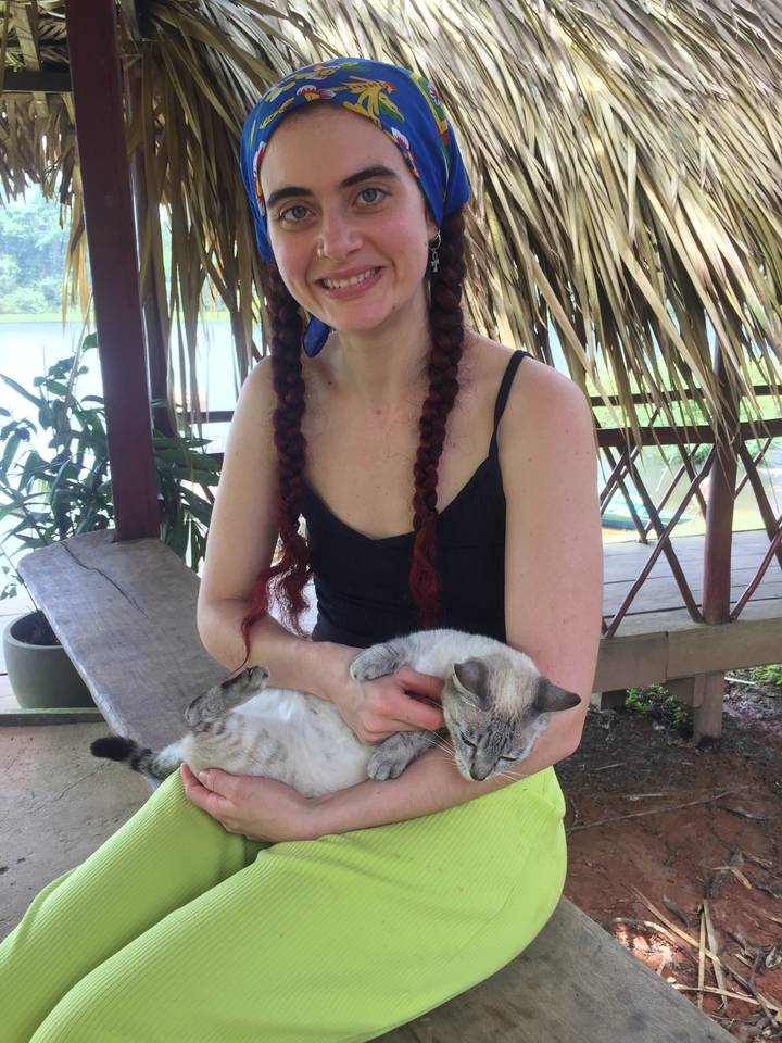 Personne assise avec un chat sur ses genoux.