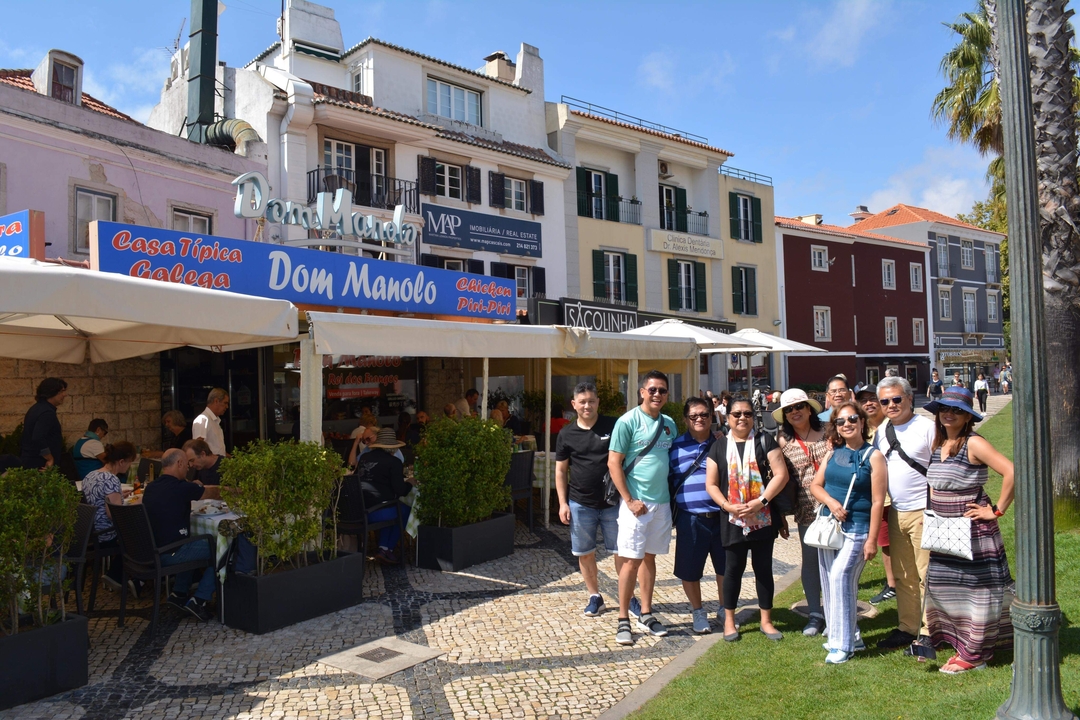 Groupe de personnes posant devant des bâtiments et des restaurants colorés.